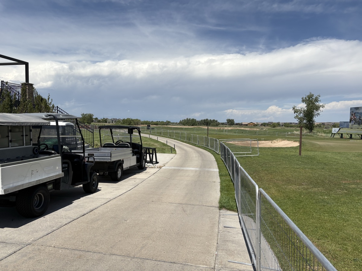 Tribute crowd control barricades lining a golf cart path at the Colorado Open