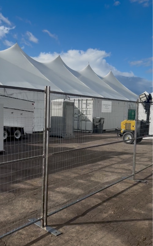 Temporary fencing installed at an outdoor event venue with tents in Colorado